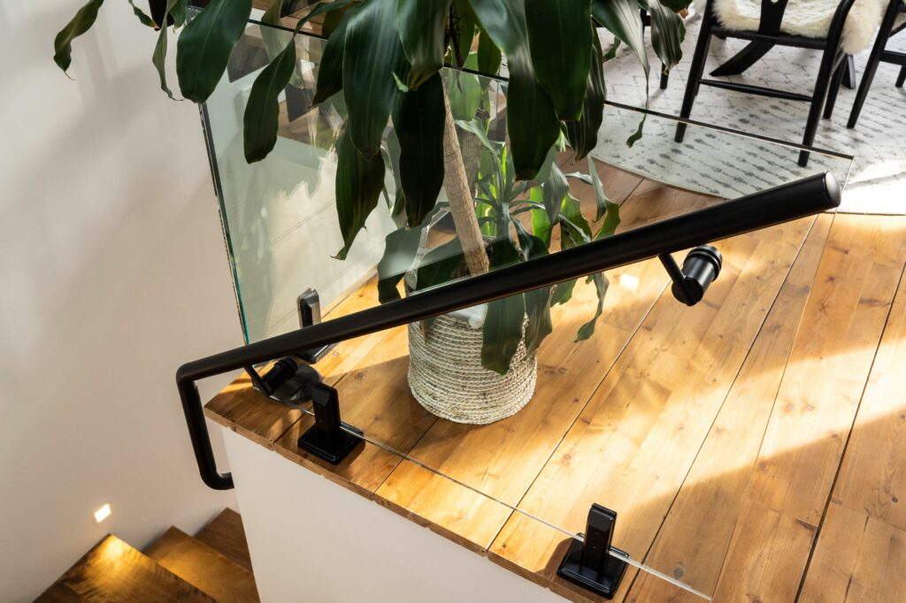 Staircase handrail installed on glass in a home.